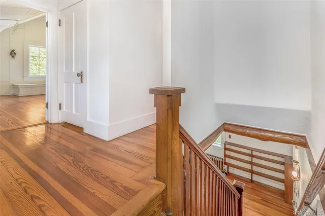 a view of a hallway with wooden floor and staircase