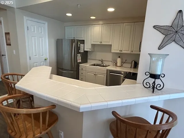 a kitchen with white cabinets stainless steel appliances and sink