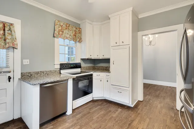 a kitchen with granite countertop white cabinets and white appliances