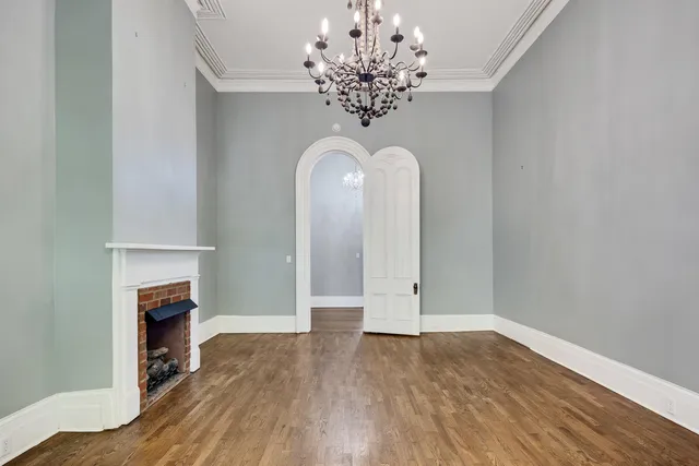a view of a livingroom with wooden floor and a chandelier