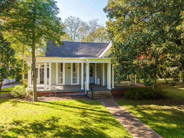 a front view of a house with a yard table and chairs