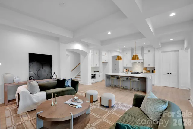 a living room with furniture a view of kitchen and a sink