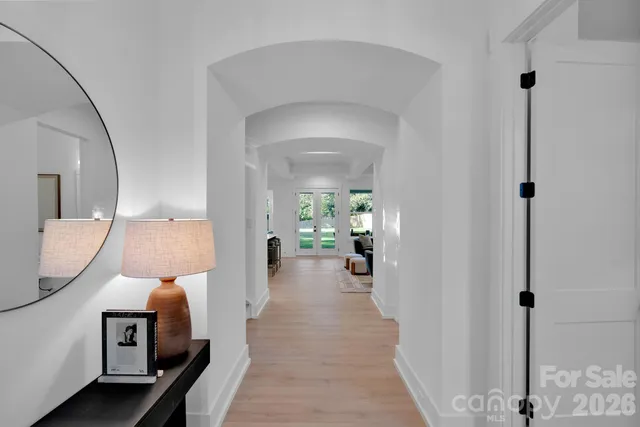 a view of a bedroom with a bed and wooden floor
