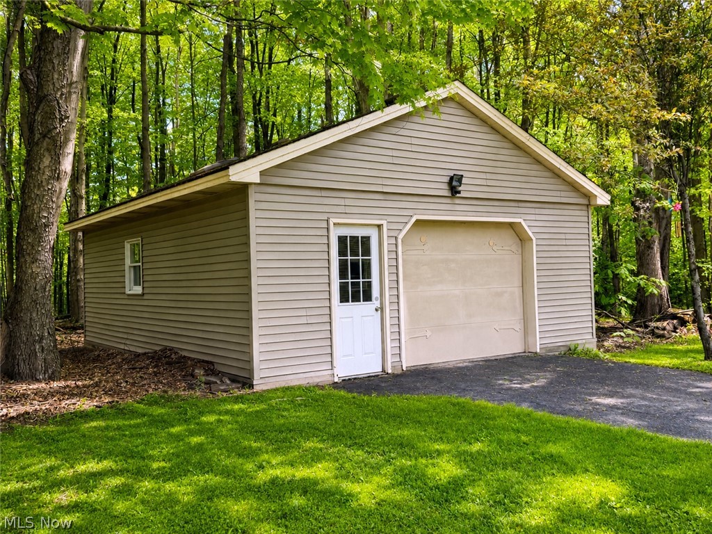 6155 Gibson Road Canfield, OH 44406 - Photo 8 of 43 Detached garage featuring horizontal vinyl siding, a single garage door, and a side entry door