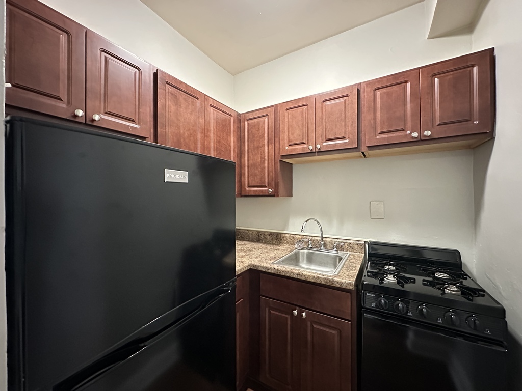 661 West Sheridan Road, Unit 208 Chicago, IL 60613 - Photo 3 of 20 a kitchen with stainless steel appliances granite countertop a sink stove and cabinets