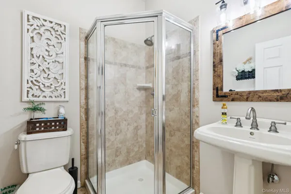 a bathroom with a sink a toilet and shower