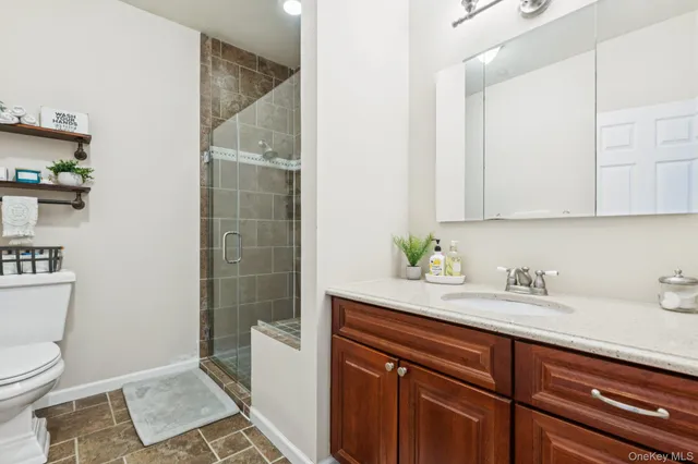 a bathroom with a sink a toilet and shower