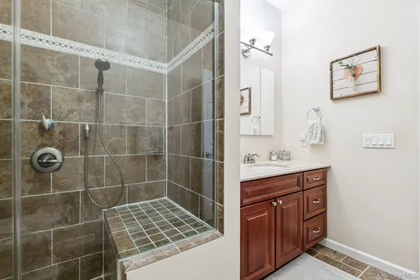 a bathroom with a granite countertop sink a toilet and shower