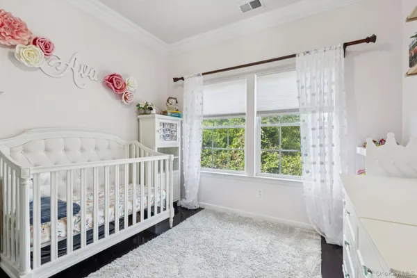 a white bed sitting in a room next to a window