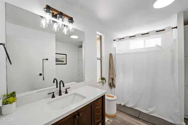 a en suite bathroom with a double vanity sink a mirror a vanity and a bathtub