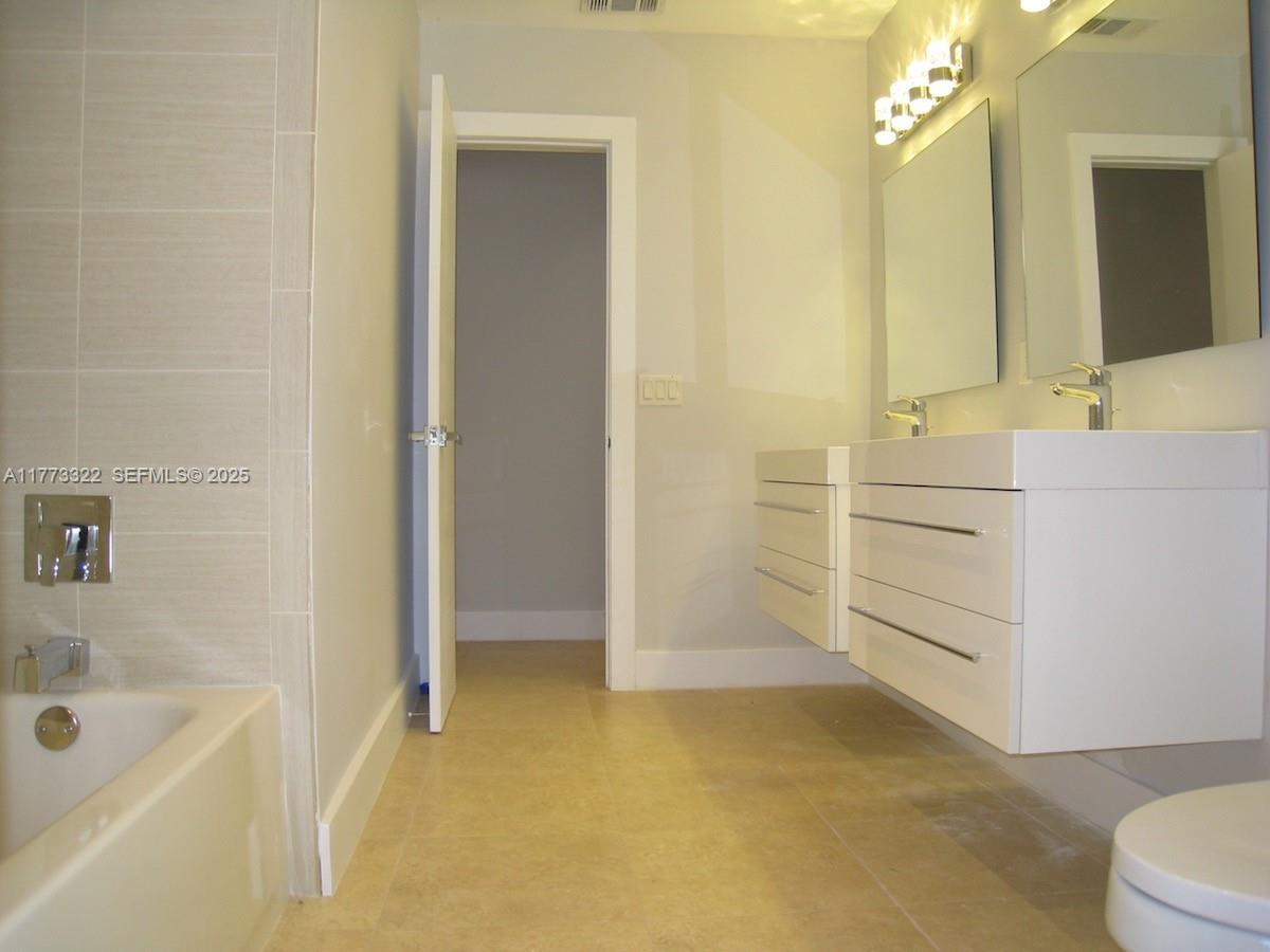 7125 Southwest 120th Street Pinecrest, FL 33156 - Photo 19 of 27 a bathroom with a bathtub sink and mirror