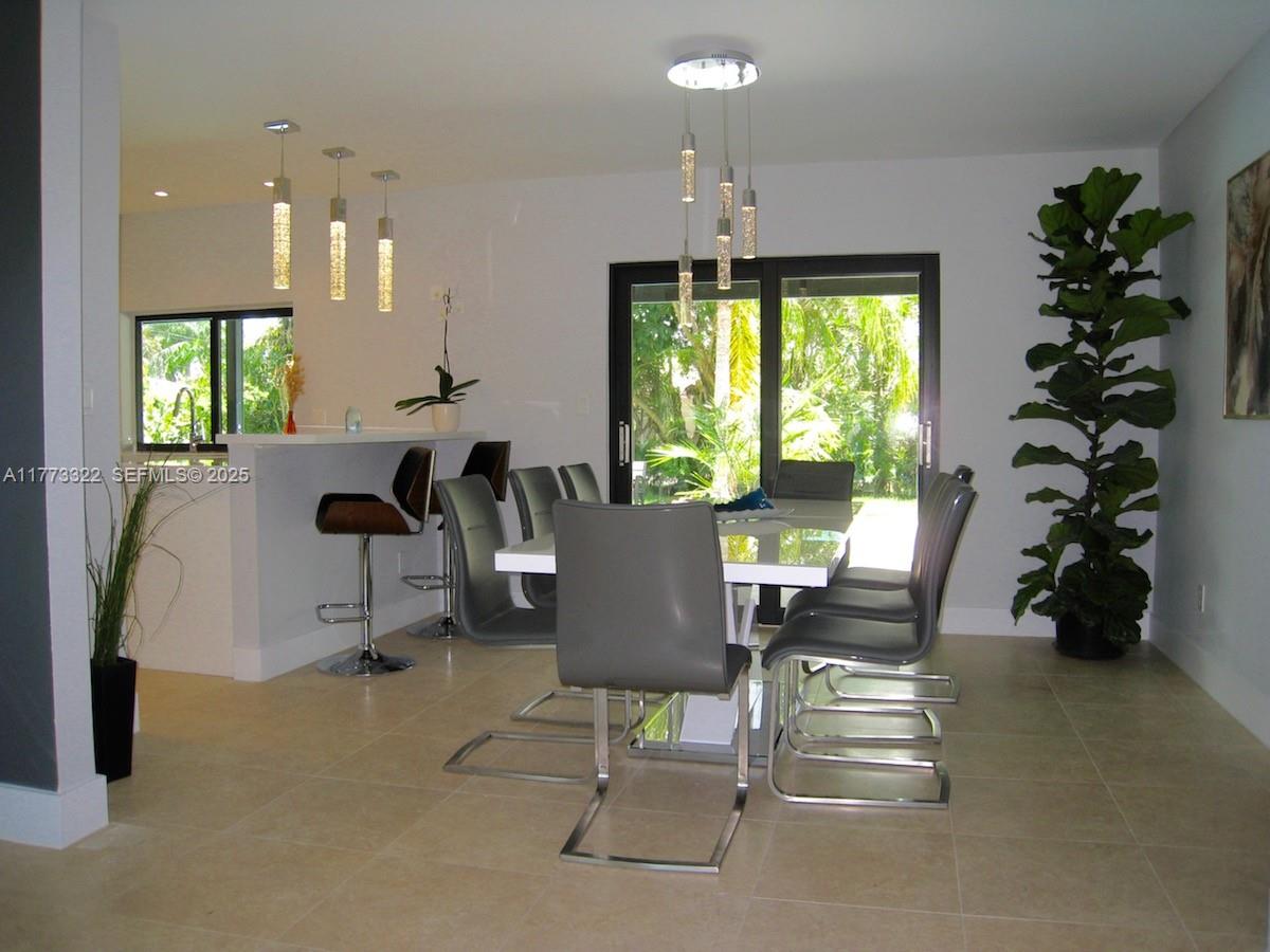 7125 Southwest 120th Street Pinecrest, FL 33156 - Photo 20 of 27 a view of a dining room with furniture window and outside view