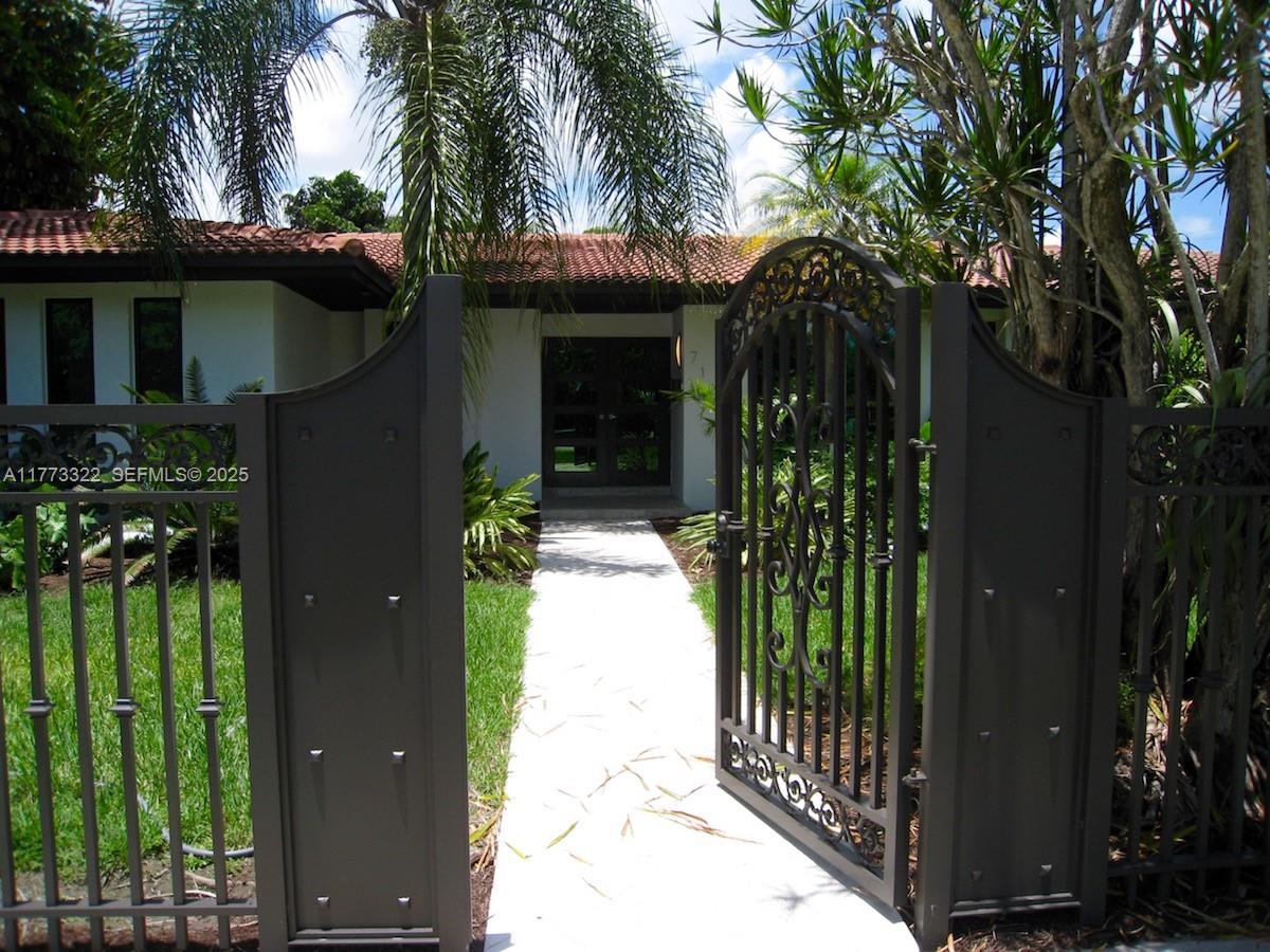 7125 Southwest 120th Street Pinecrest, FL 33156 - Photo 24 of 27 front view of a house with a garden