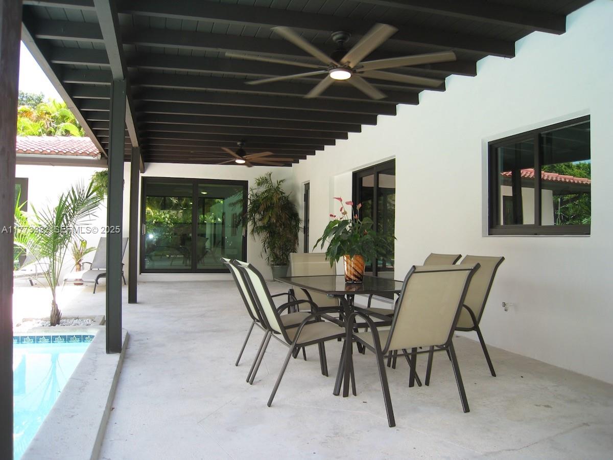 7125 Southwest 120th Street Pinecrest, FL 33156 - Photo 9 of 27 a view of a porch with furniture and a yard