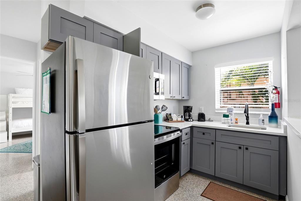2311 Bay Boulevard Indian Rocks Beach, FL 33785 - Photo 34 of 80 a kitchen with stainless steel appliances a refrigerator sink and cabinets