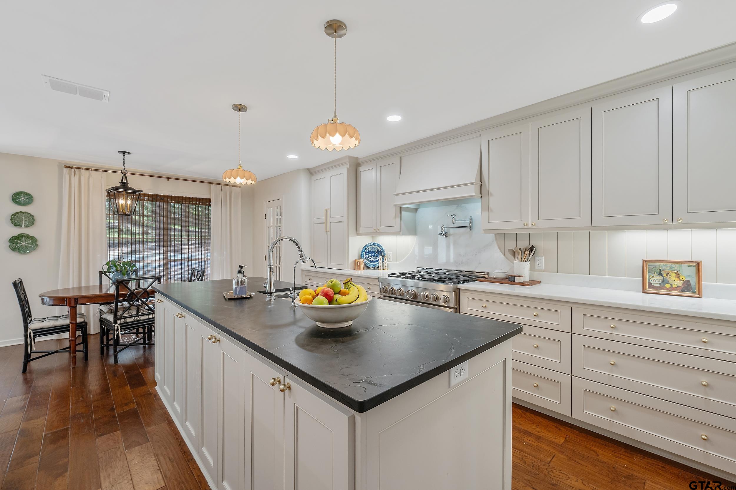 16708 Beddingfield Road Flint, TX 75762 - Photo 11 of 40 a kitchen with a sink a kitchen island with white cabinets and wooden floor