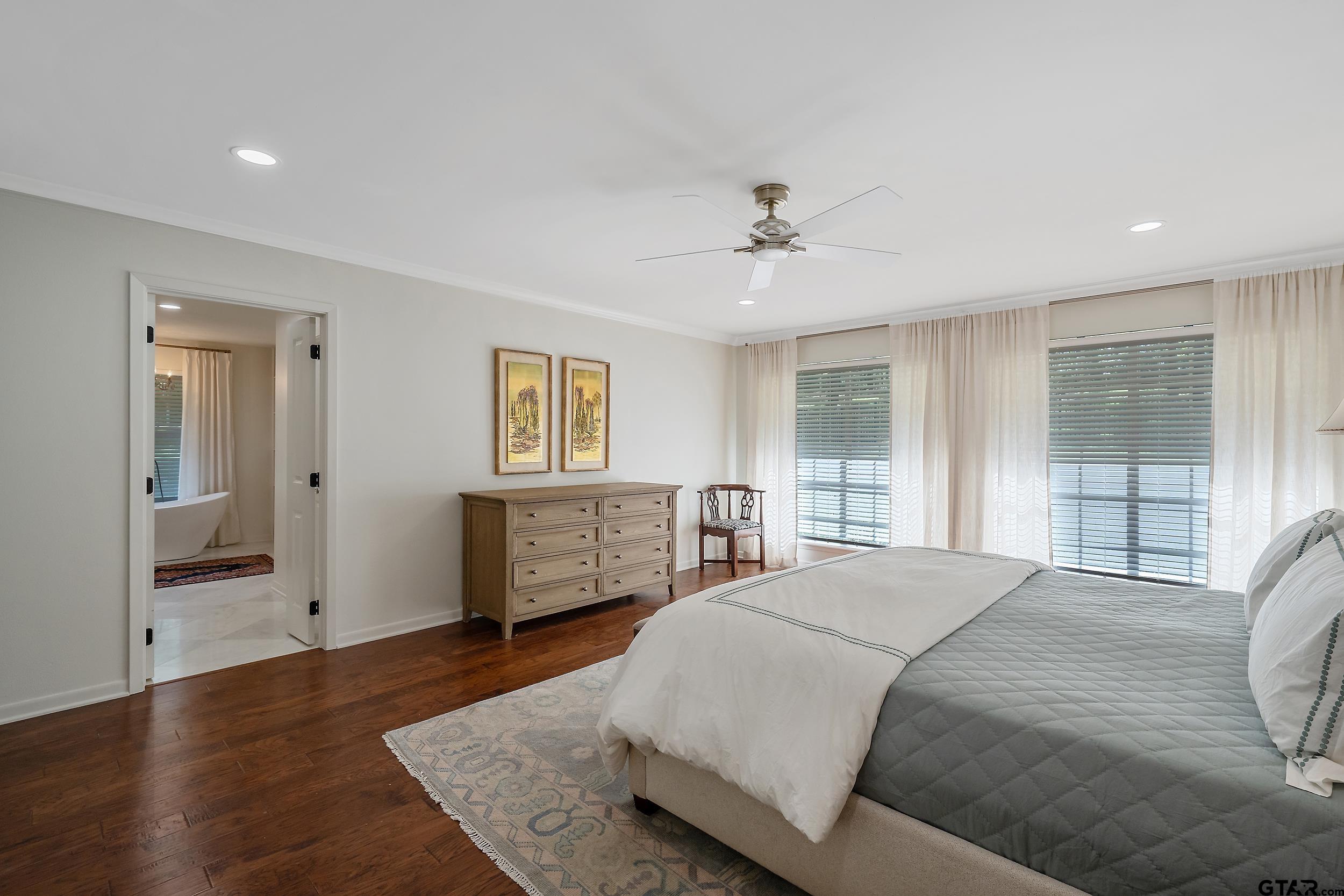 16708 Beddingfield Road Flint, TX 75762 - Photo 21 of 40 a spacious bedroom with a large bed and a chandelier