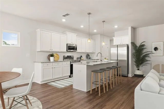 a kitchen with white cabinets and stainless steel appliances