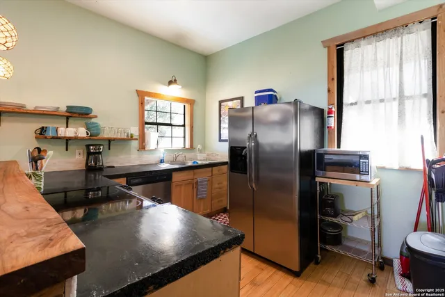 a kitchen with stainless steel appliances granite countertop a refrigerator a stove and a sink