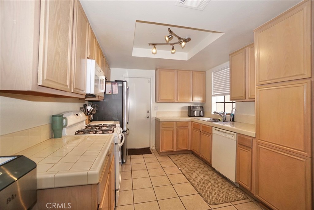 44557 La Paz Road Temecula, CA 92592 - Photo 7 of 24 a kitchen with stainless steel appliances granite countertop a sink stove and refrigerator