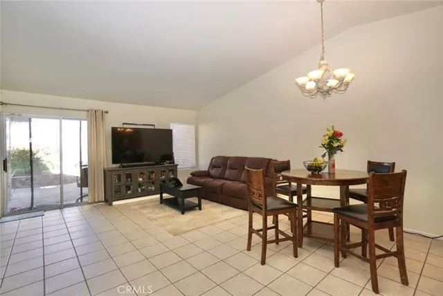 a living room with furniture a dining table and a chandelier