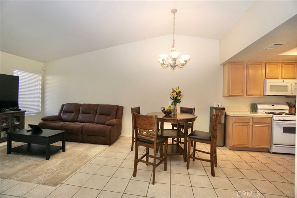 44557 La Paz Road Temecula, CA 92592 - Photo 10 of 24 a living room with furniture a dining table and a chandelier