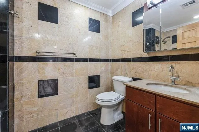 a bathroom with a granite countertop toilet sink and mirror