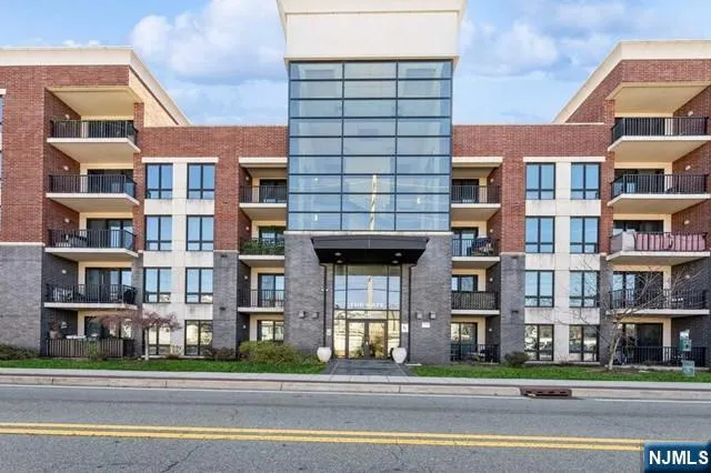 a front view of a brick building next to a road
