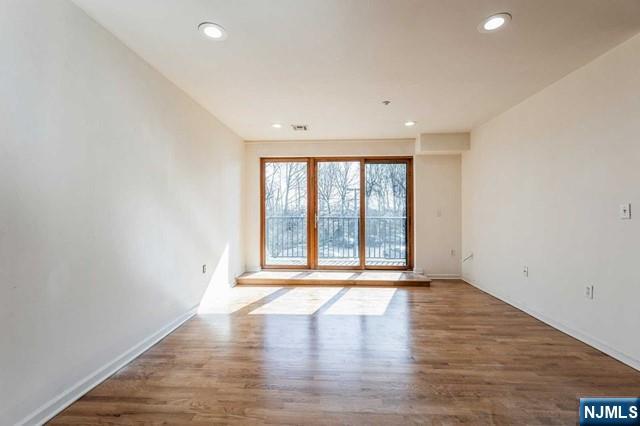17 Meadow Road, Unit 401 Rutherford, NJ 07070 - Photo 3 of 29 a view of an empty room with wooden floor and a window