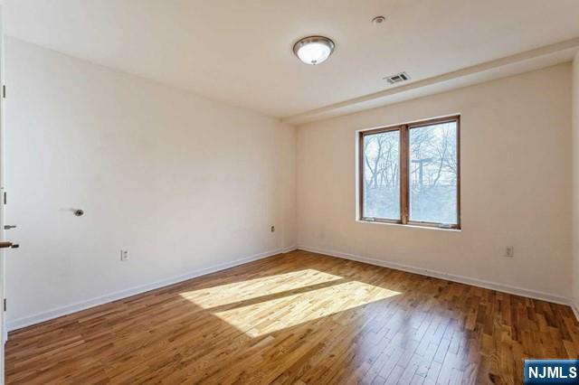17 Meadow Road, Unit 401 Rutherford, NJ 07070 - Photo 10 of 29 an empty room with wooden floor and windows