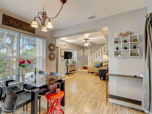 a view of a dining room with furniture a chandelier and wooden floor