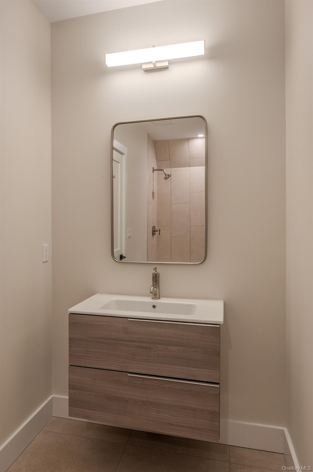 12 Depot, Unit 103 (PEARL WAY) Westhampton Beach, NY 11978 - Photo 23 of 28 a bathroom with a sink and a mirror