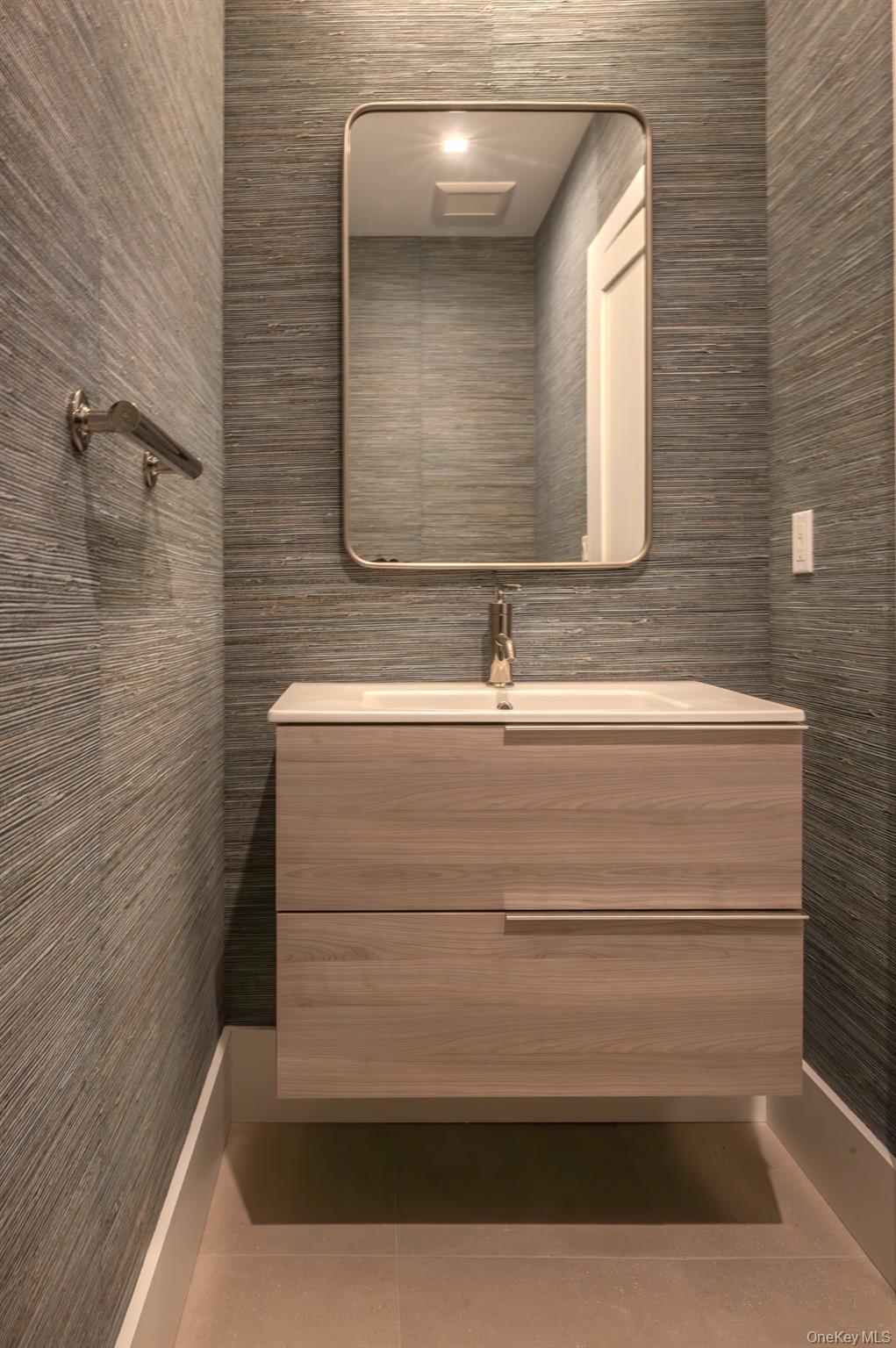 12 Depot, Unit 103 (PEARL WAY) Westhampton Beach, NY 11978 - Photo 24 of 28 a bathroom with a sink and a mirror