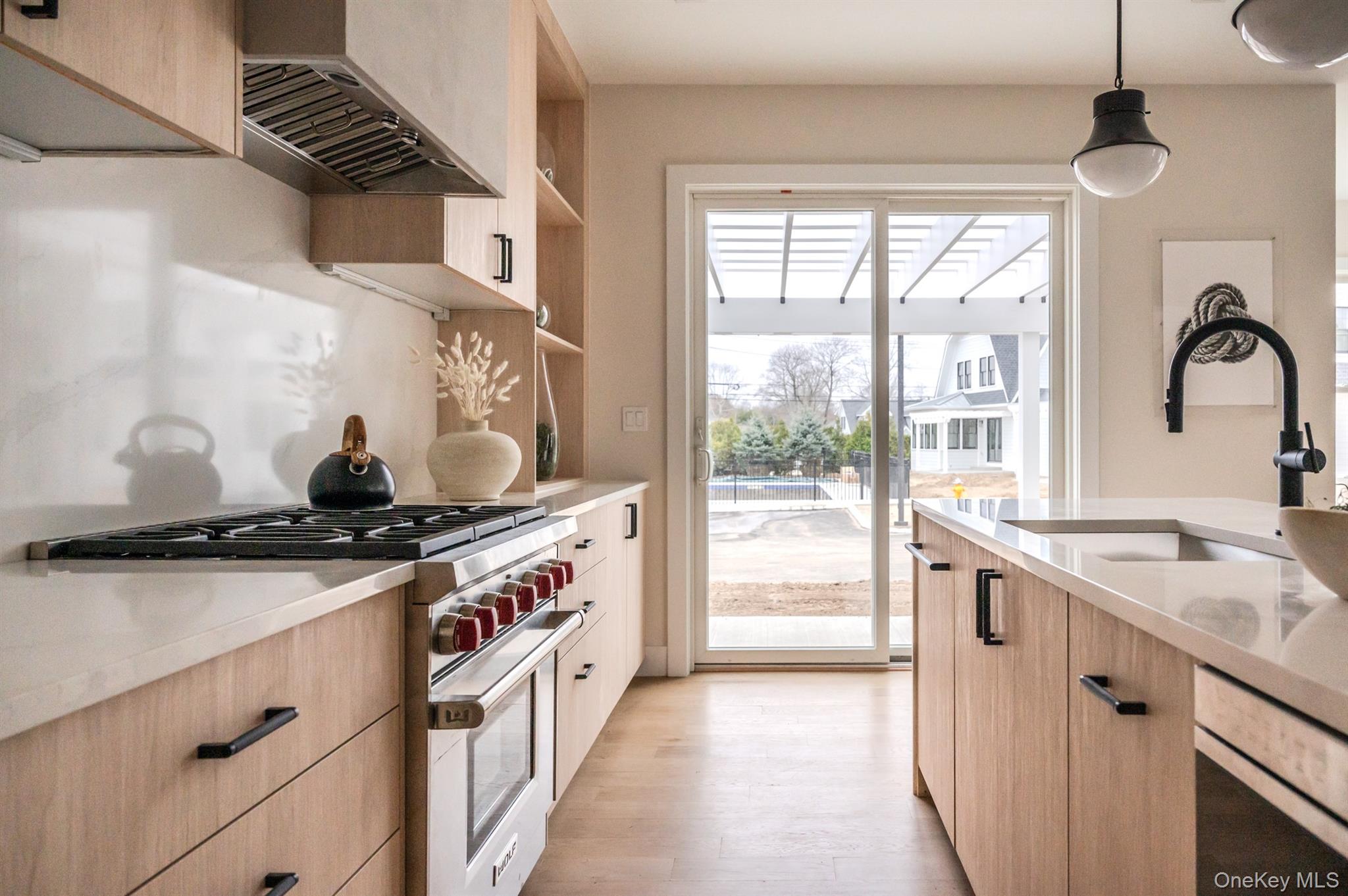 12 Depot, Unit 103 (PEARL WAY) Westhampton Beach, NY 11978 - Photo 26 of 28 a kitchen with a sink stove top oven and cabinets