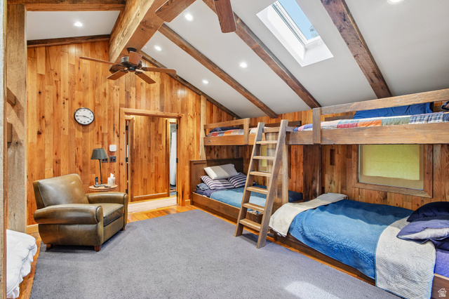 10205 East Moose Loop Road Salt Lake City, UT 84121 - Photo 25 of 50 Vaulted ceiling bedroom featuring wood-finish walls, exposed wood beams, and a skylight
