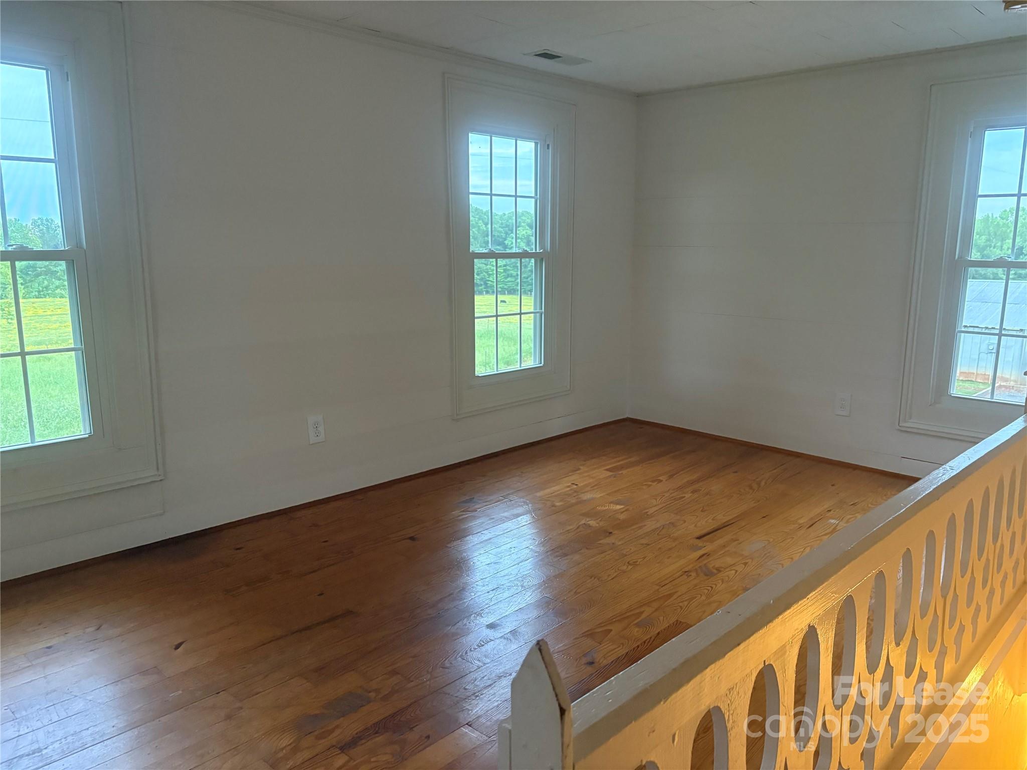 6625 Long Road Matthews, NC 28104 - Photo 19 of 23 an empty room with wooden floor and windows