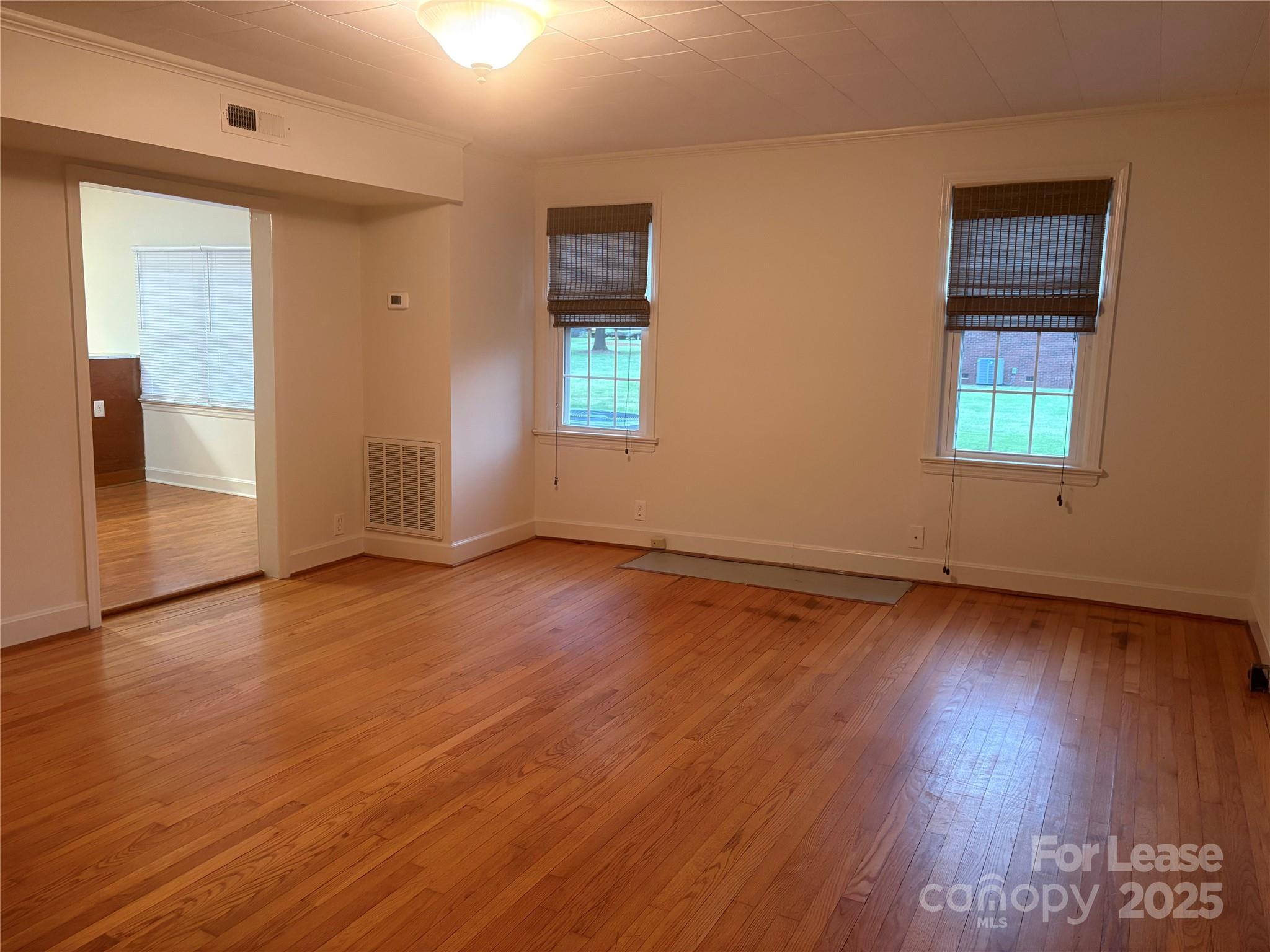 6625 Long Road Matthews, NC 28104 - Photo 7 of 23 an empty room with wooden floor and windows