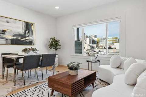 a living room with furniture potted plant and a large window