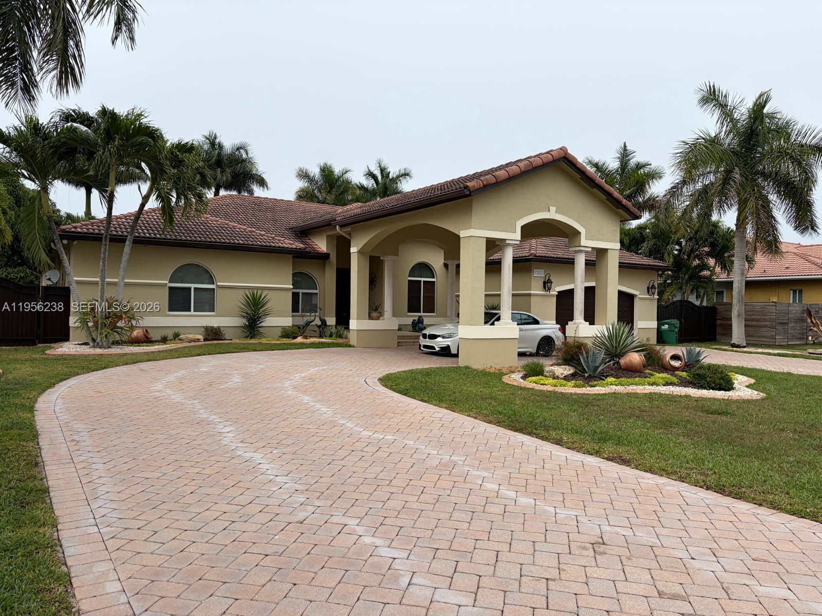 13163 Southwest 191st Terrace, Unit 1 Miami, FL 33177 - Photo 2 of 3 a front view of a house with yard and green space
