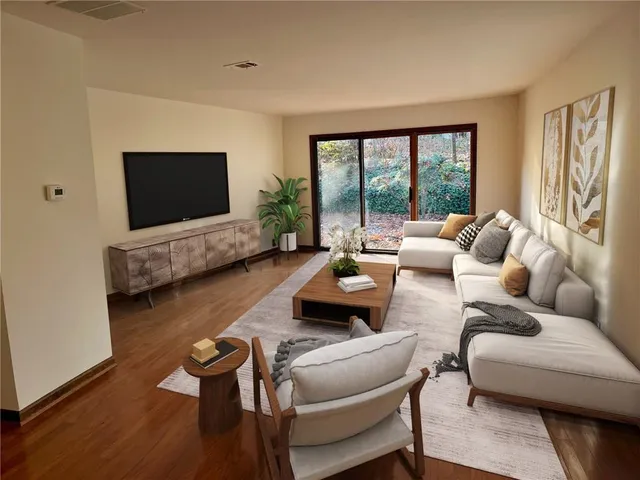 a living room with furniture wooden floor and a flat screen tv