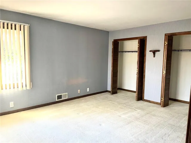 an empty room with windows and closet