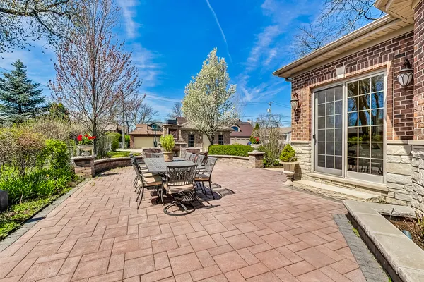a chair and table sitting in backyard with a large tree