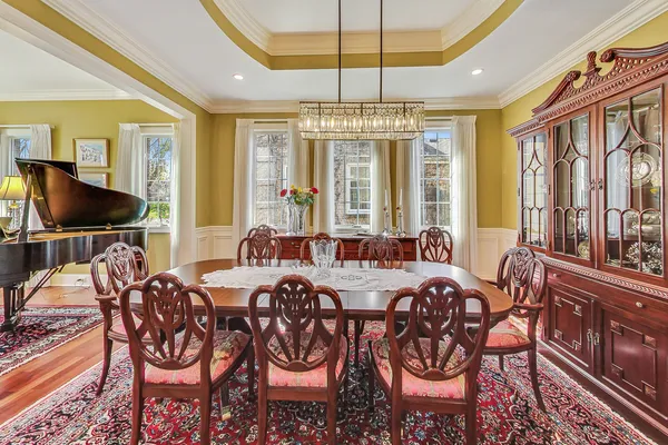 a kitchen with stainless steel appliances kitchen island granite countertop a refrigerator a stove a sink dishwasher a dining table and chairs with wooden floor