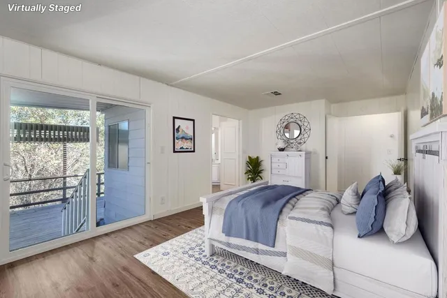 a bedroom with a large bed and wooden floor