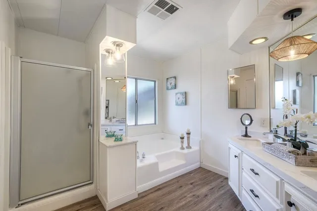 a bathroom with a double vanity sink a mirror and a bathtub