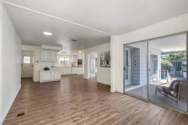 a view of a living room kitchen with furniture and wooden floor