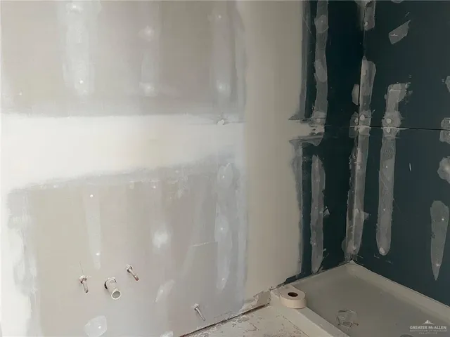 an empty room with a mirror and windows