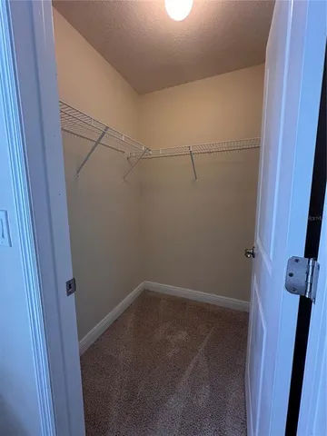 an empty room with a ceiling fan and windows