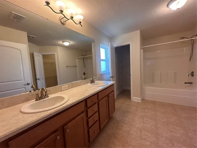 an empty room with windows and chandelier fan