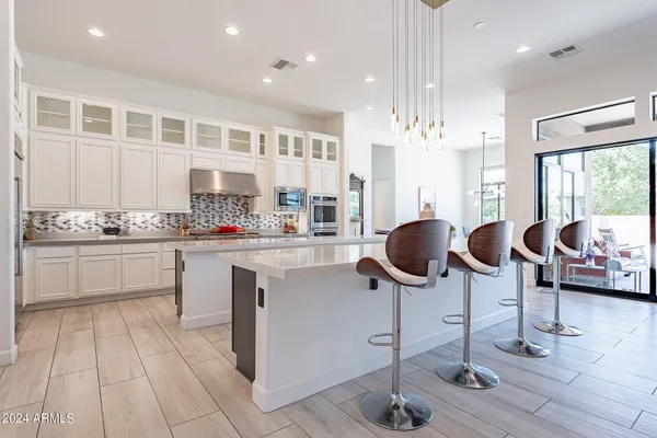 a kitchen with cabinets and chairs